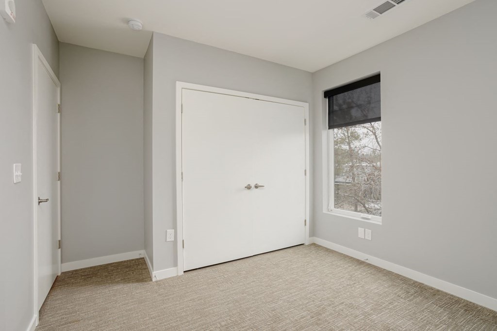 a bedroom with a white door and a window