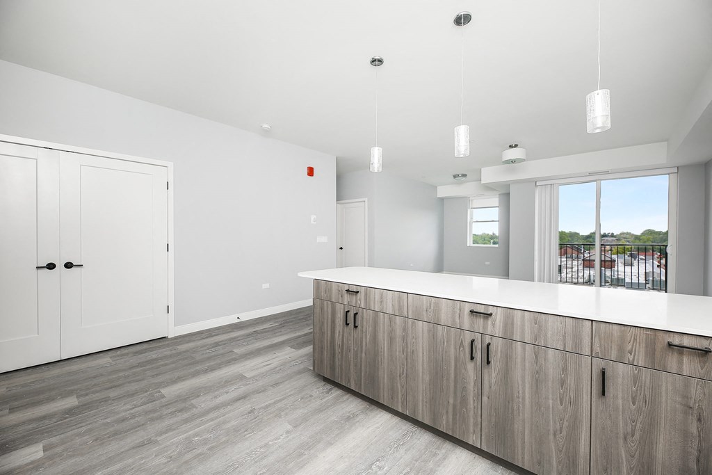 a large kitchen with a white counter top and wooden cabinets
