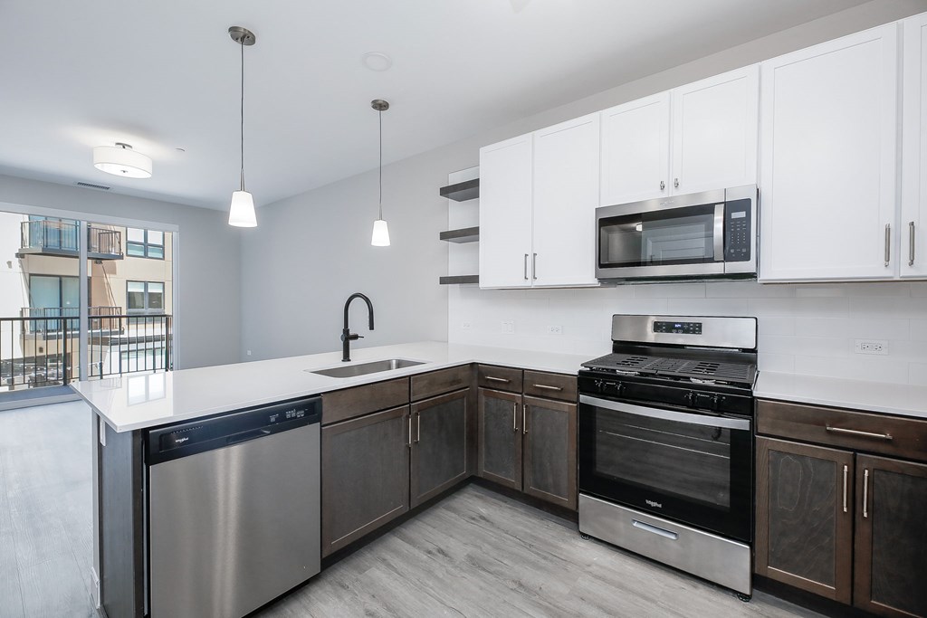 A modern kitchen with stainless steel appliances and white cabinets.