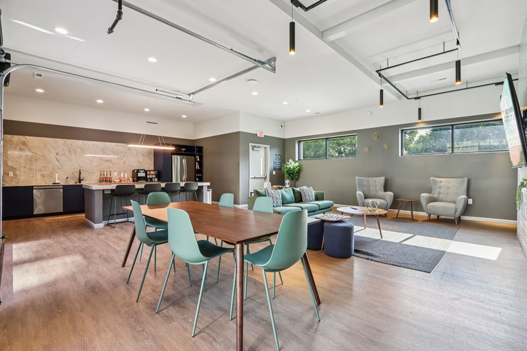 A modern dining room with a wooden table and green chairs.