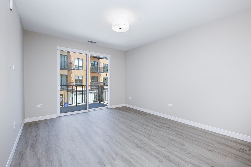 A spacious room with a view of a building through a glass door.