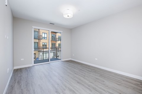 A spacious room with a view of a building through a glass door.