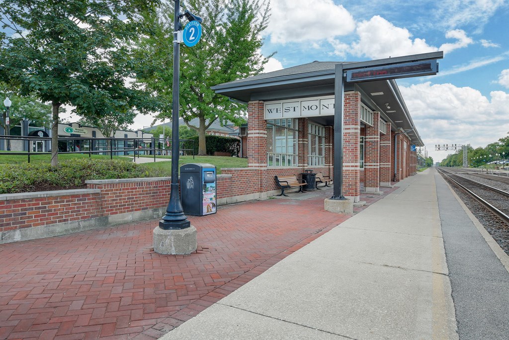 a train station with a bench on the side of the tracks
