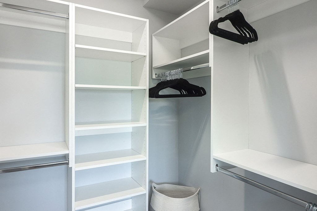 A white closet with shelves and hangers.