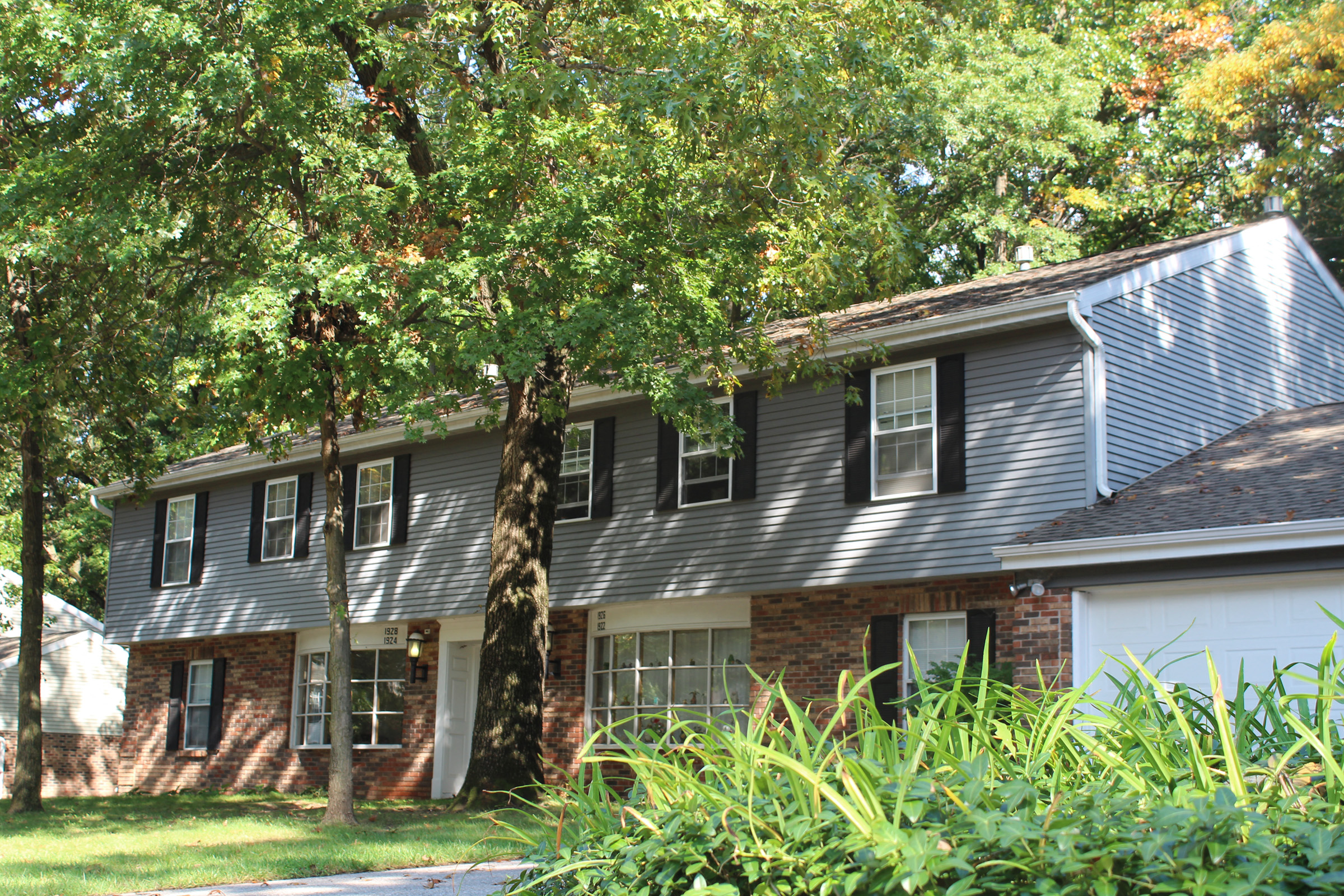 a house with a blue roof and a tree in the yard