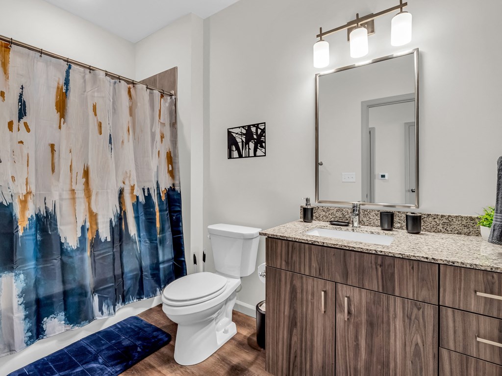 a bathroom with a toilet sink and shower and a mirror