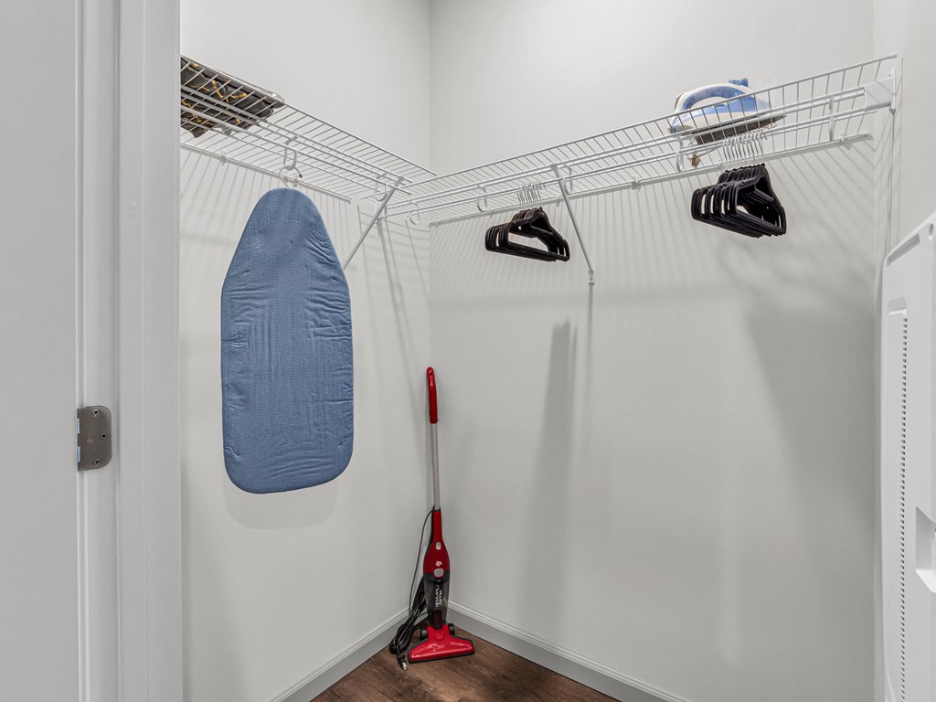 a closet with hangers and ironing board