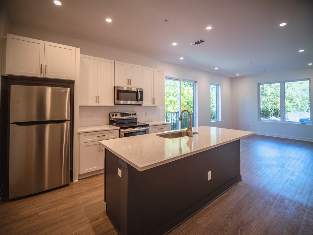 a large kitchen with white cabinets and stainless steel appliances