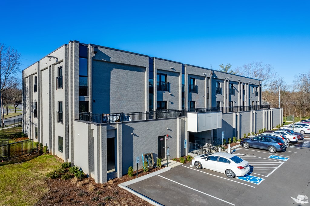 A modern building with a parking lot in front.