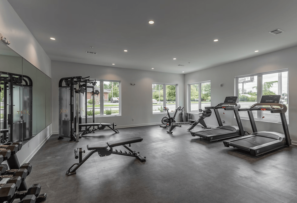 A spacious gym with treadmills, elliptical machines, and other exercise equipment.