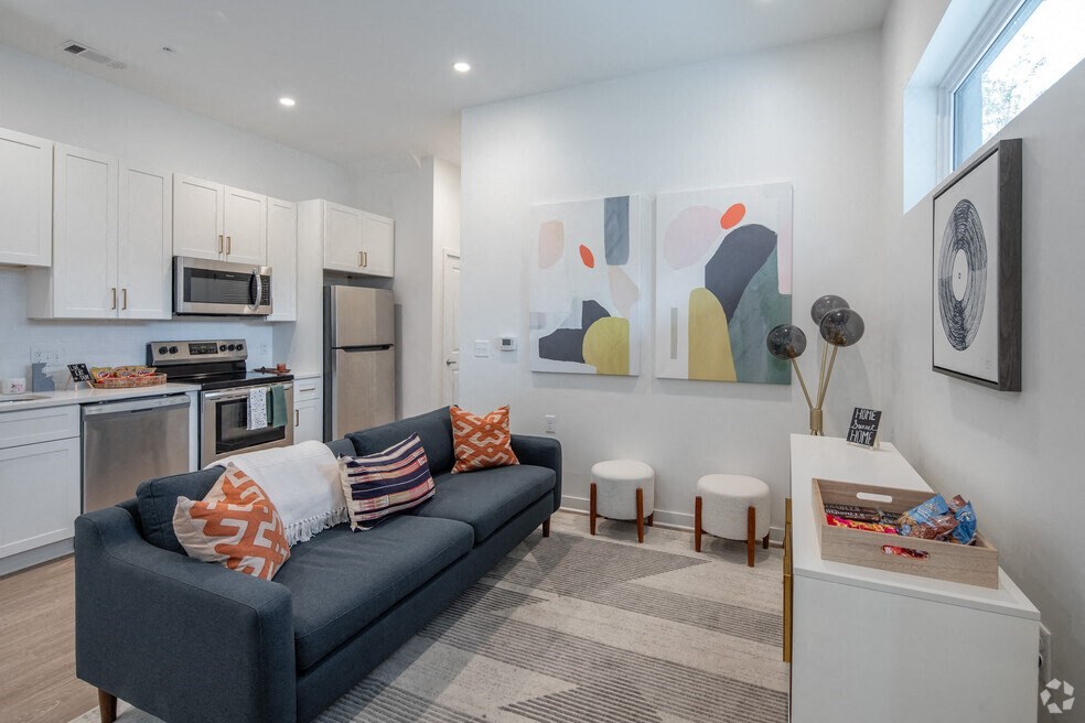 a living room with a couch and a kitchen with a sink