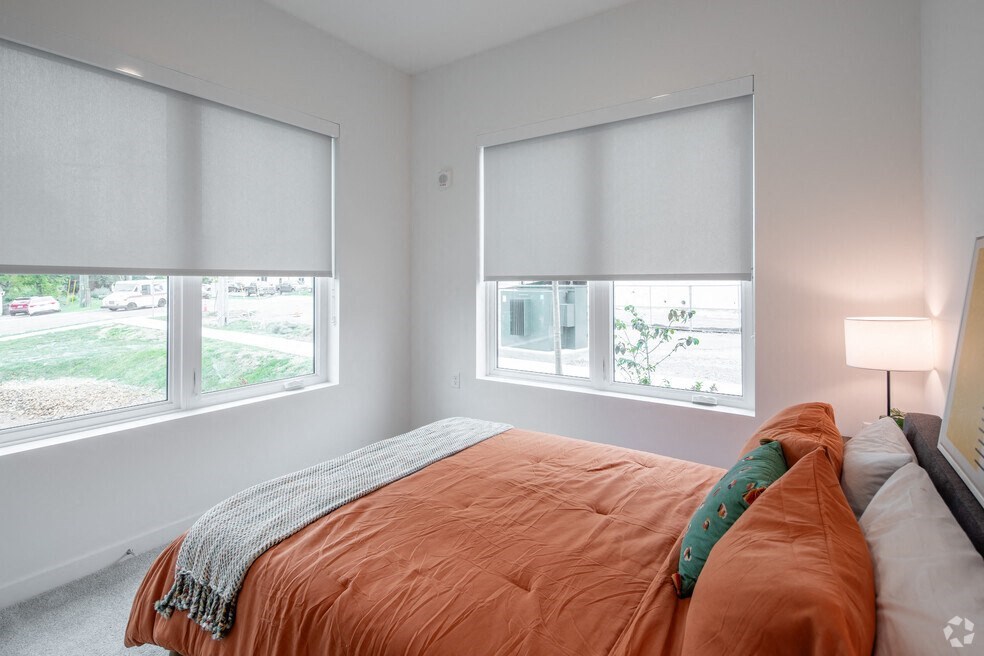 a bedroom with a bed and two windows