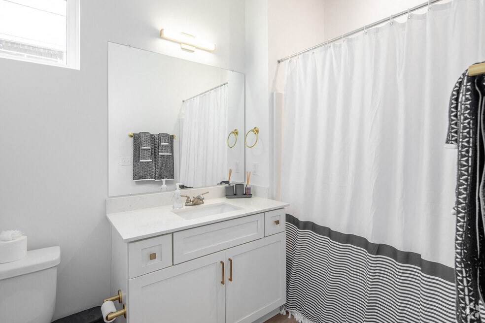 a bathroom with a sink and a shower and a mirror