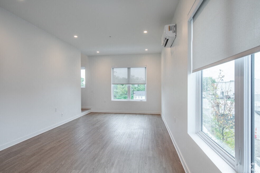 a living room with white walls and a large window