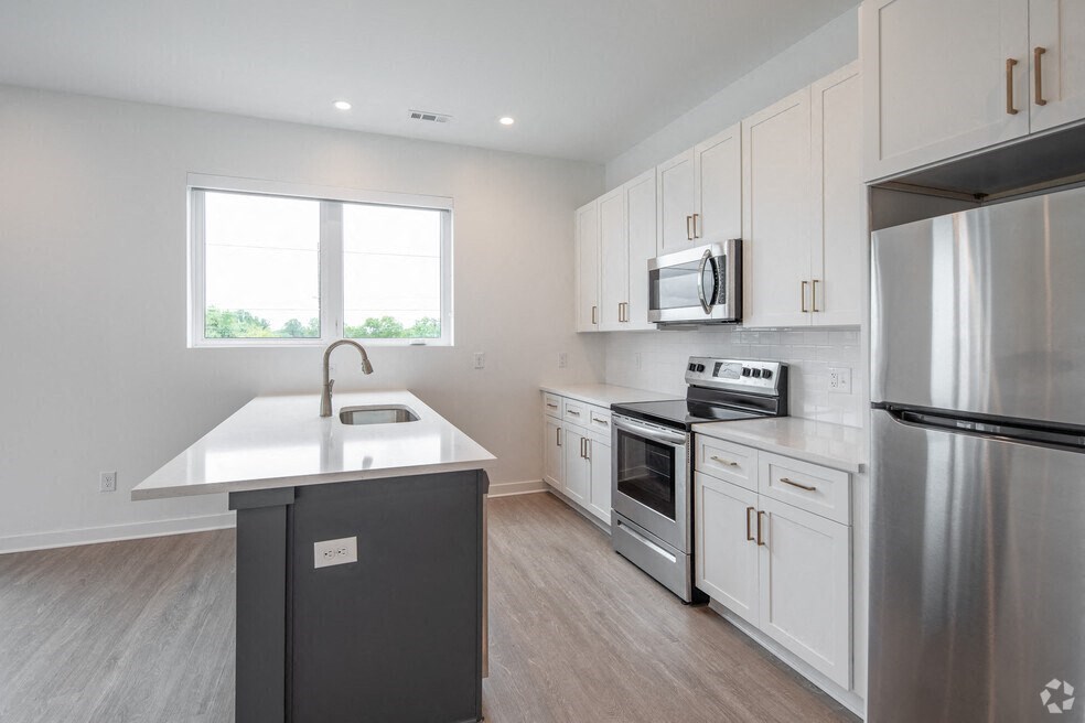 a kitchen with white cabinets and stainless steel appliances