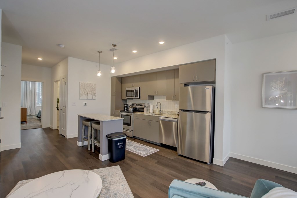 A modern kitchen with stainless steel appliances and a marble island.