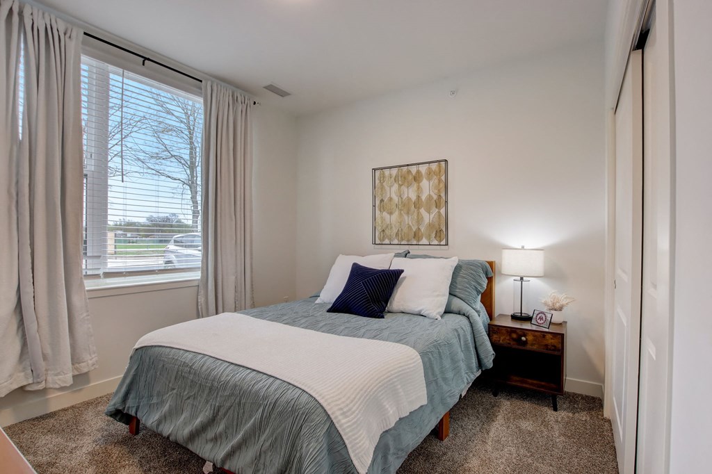 a bedroom with a bed and a large window
