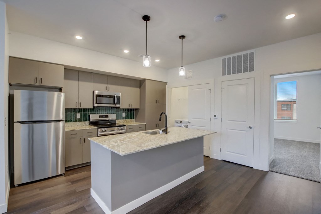 a kitchen with stainless steel appliances and a marble counter top