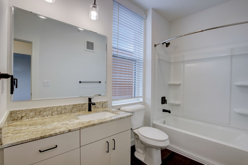 A bathroom with a sink, toilet, and bathtub.