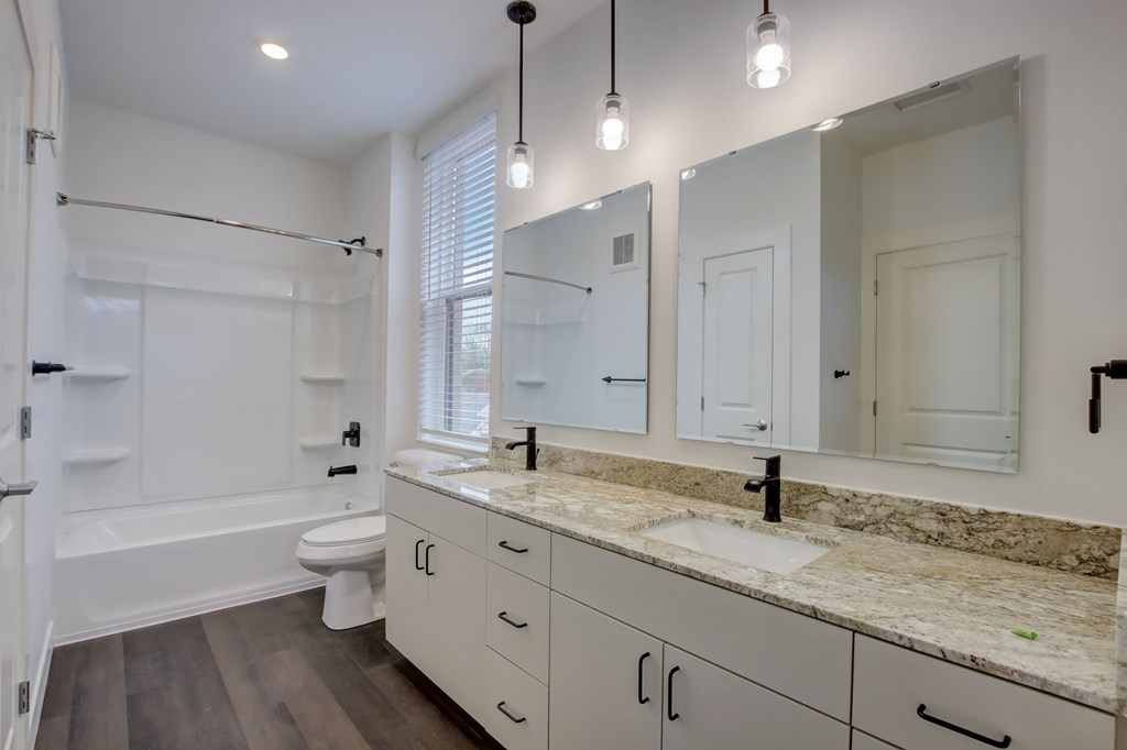 A bathroom with a marble countertop and a large mirror.