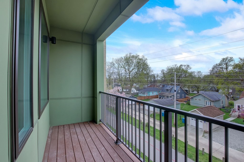 a balcony with a view of a neighborhood and a large window