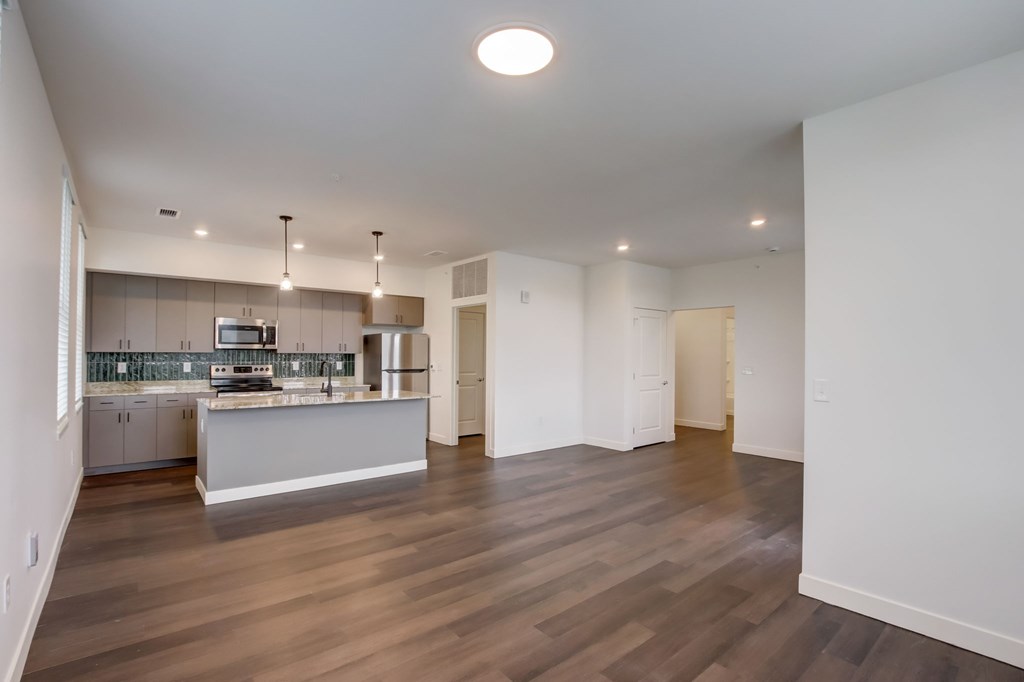A spacious kitchen with a dining area and a living room.