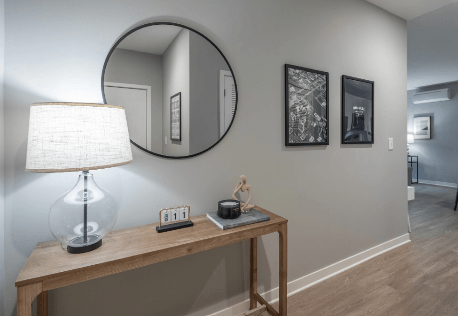 a mirror and a lamp on a table in a living room