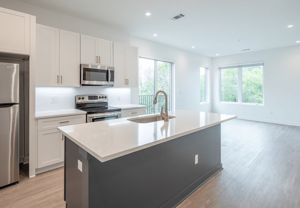 A modern kitchen with a large island and stainless steel appliances.