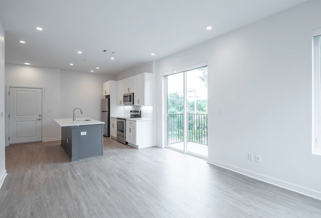 A kitchen with a sink and a refrigerator in a white room.
