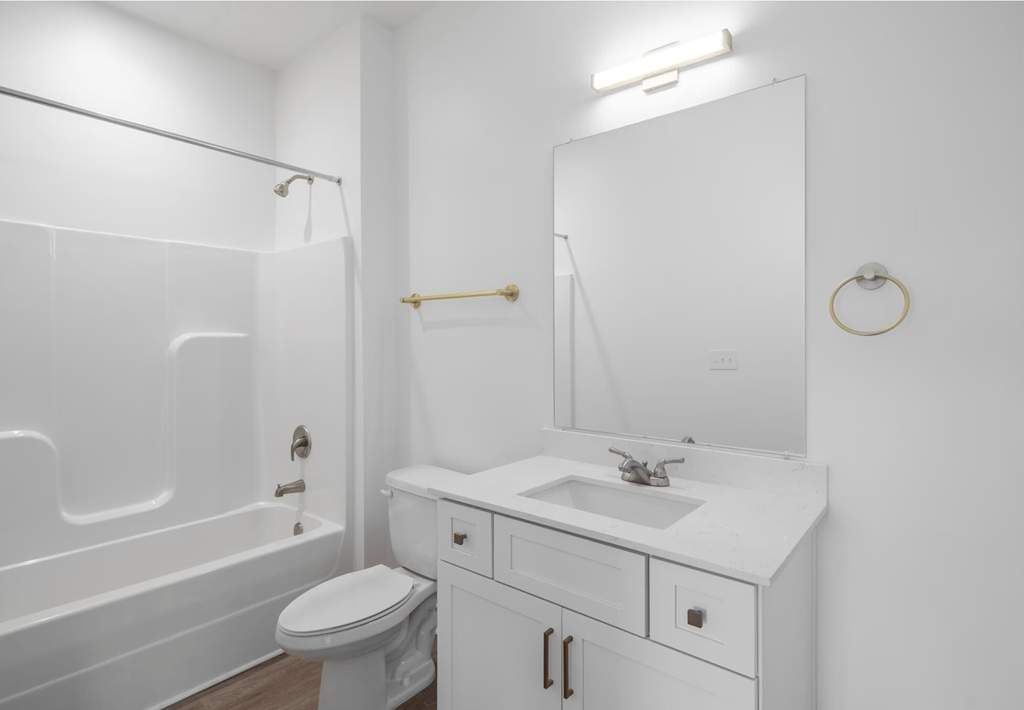 A white bathroom with a toilet, sink, and bathtub.