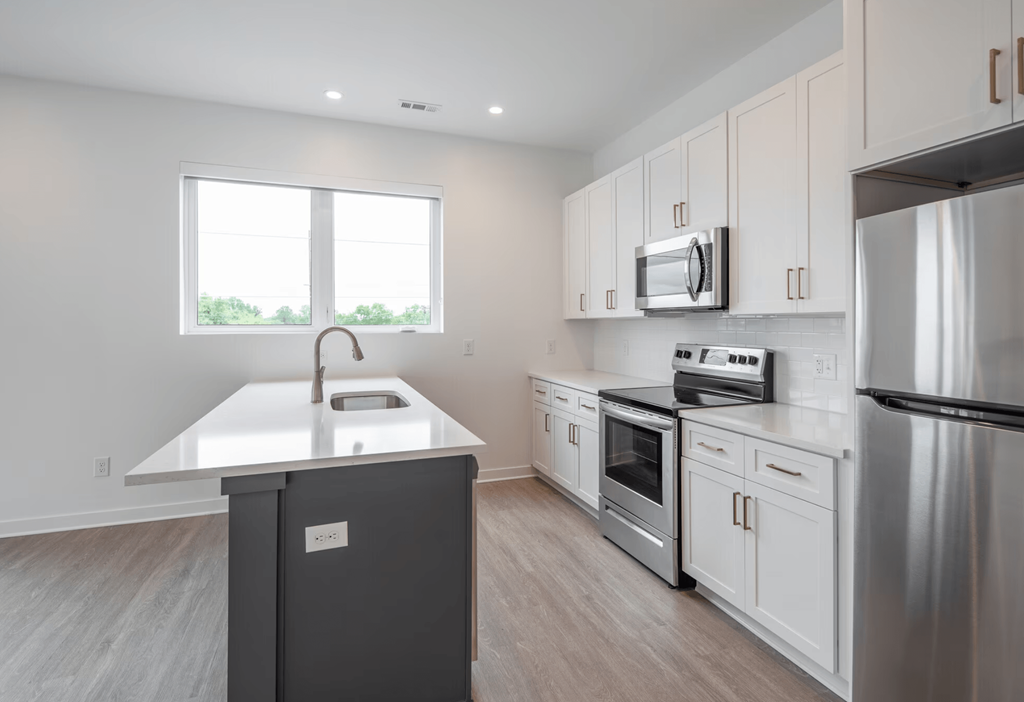 A kitchen with a stainless steel refrigerator, oven, and microwave.