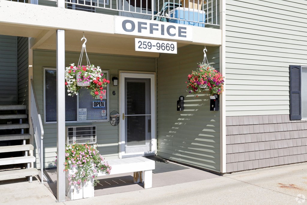 the front of an office building with flowers on the front porch