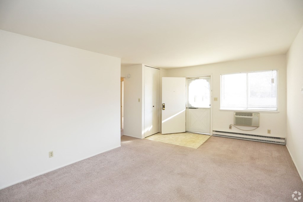 an empty living room with white walls and a carpet floor
