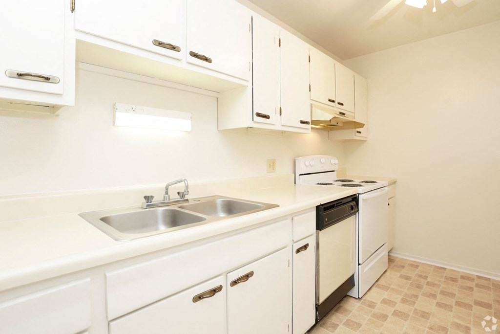 a kitchen with white cabinets and a sink and a stove