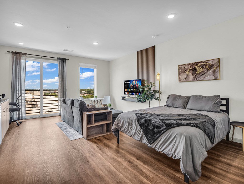 a studio bedroom with a bed and couch
