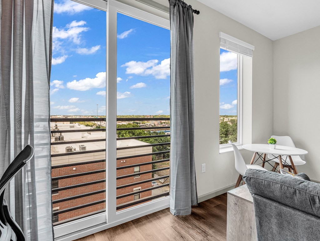 a living room with sliding glass doors and a balcony with a view