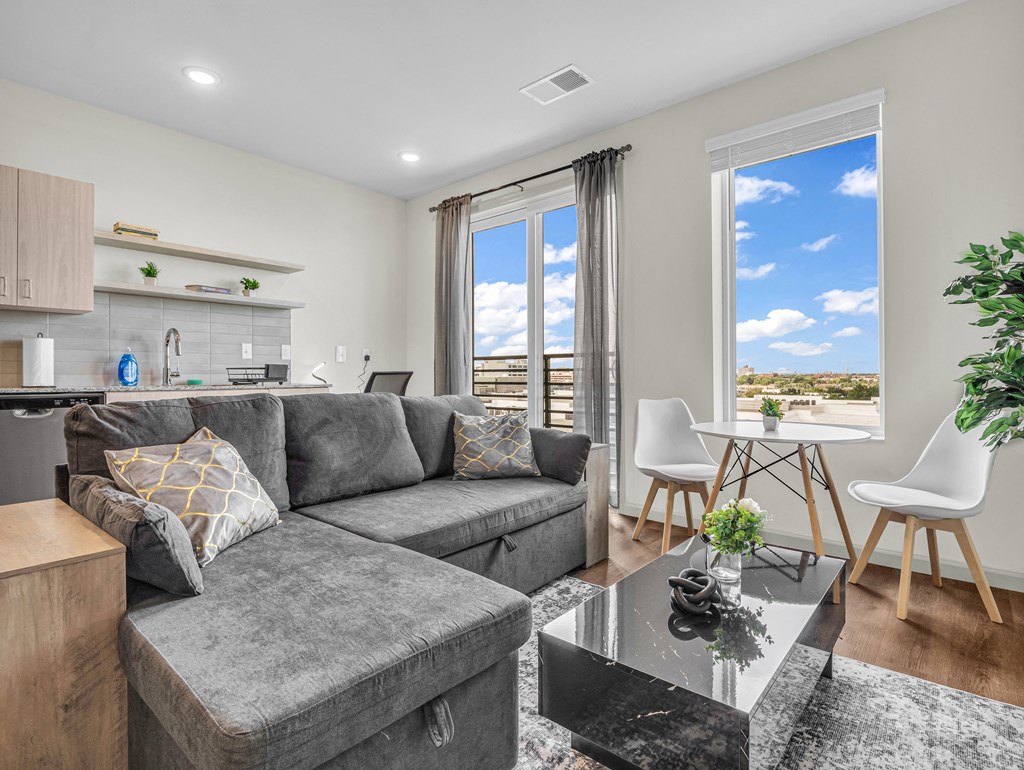 a living room with a gray couch and a glass coffee table