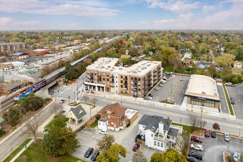 an aerial view of a city street with buildings and a train