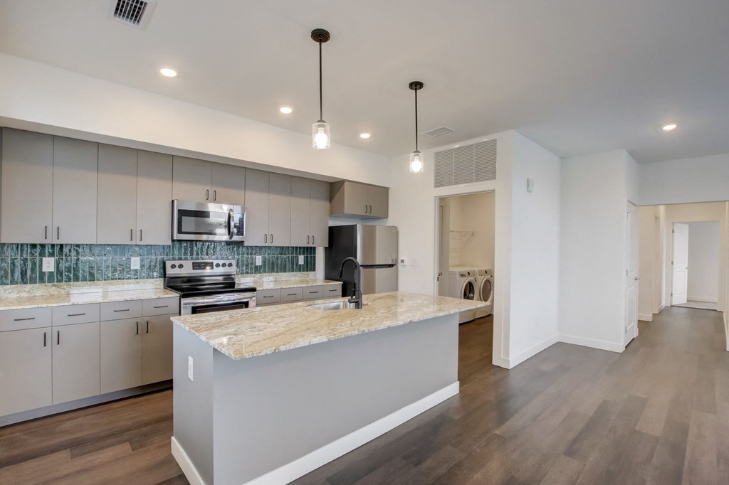 a kitchen with white cabinets and a marble counter top