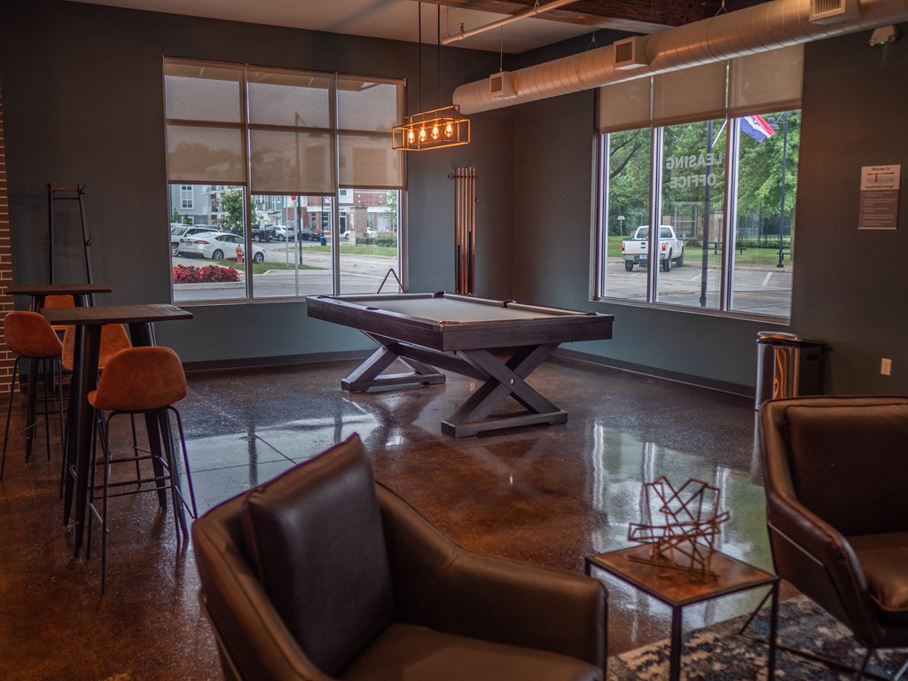 a game room with a pool table and chairs