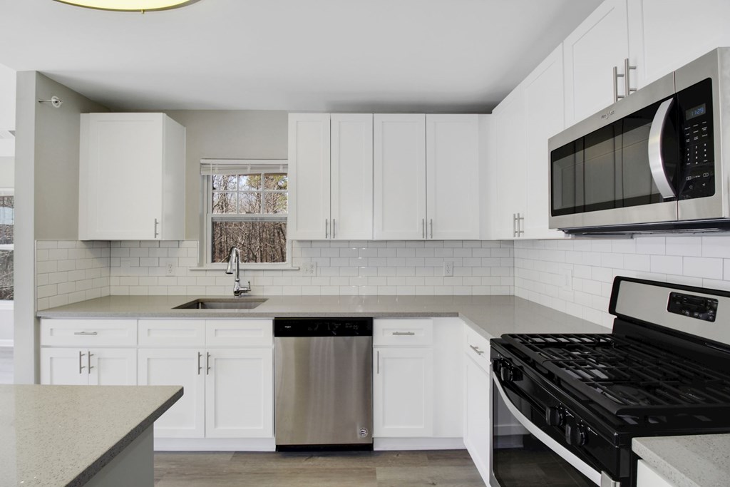 a kitchen with white cabinets and a stove and a microwave