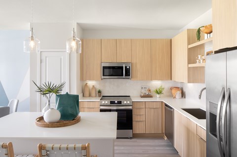 A modern kitchen with wooden cabinets and stainless steel appliances.