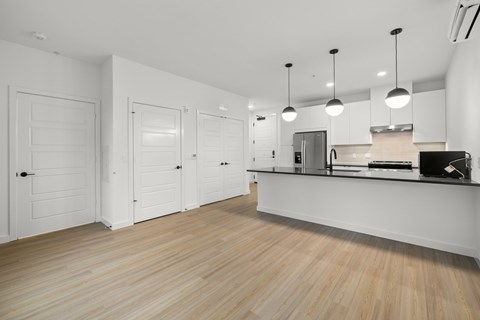 A kitchen with white cabinets and a wooden floor.