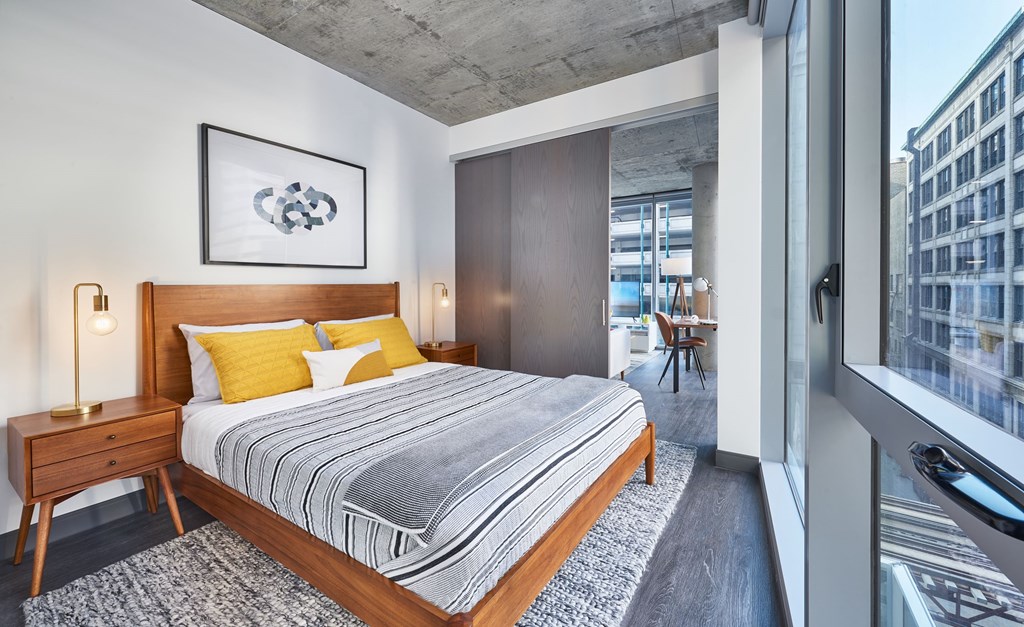 Furnished bedroom model with floor to ceiling windows 