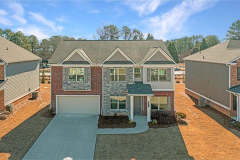 a brick house with a driveway and a garage door