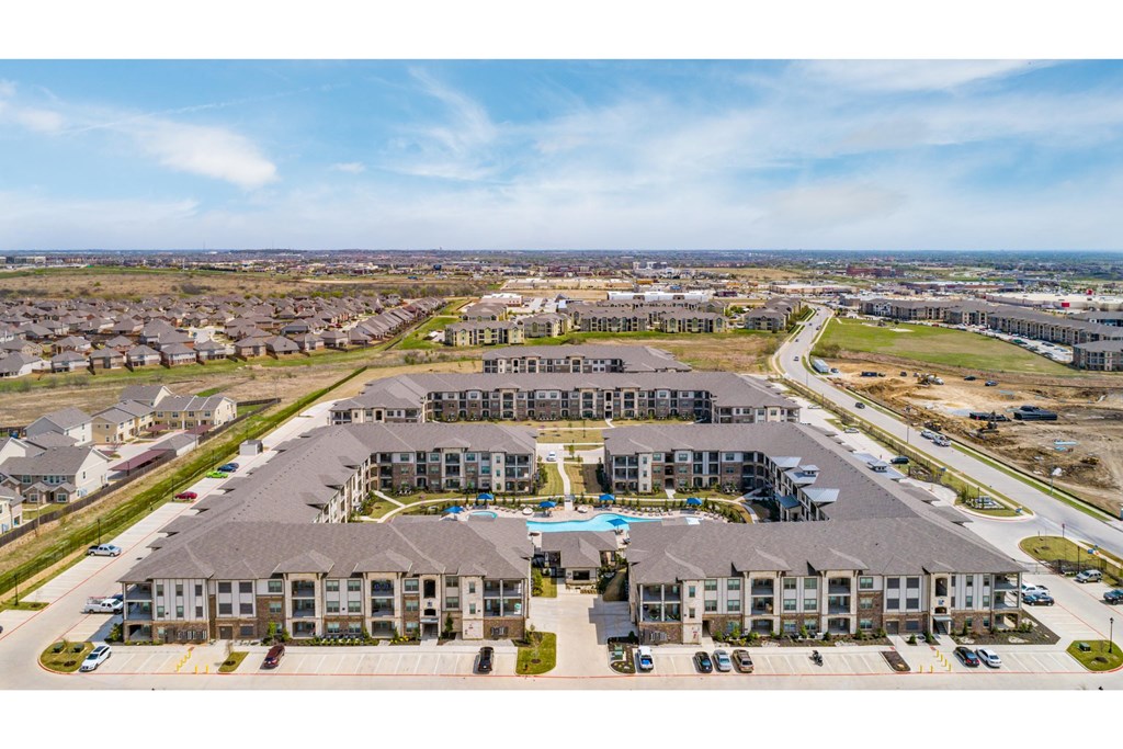 an aerial view of a large building with a swimming pool