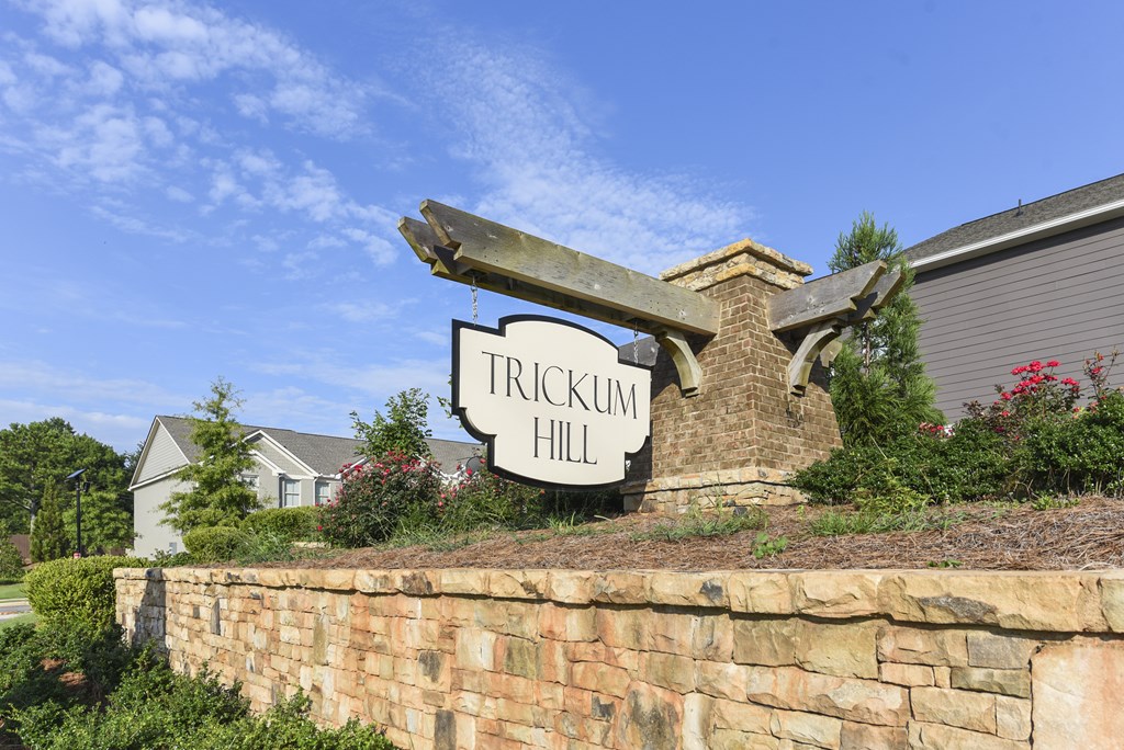 a sign for trickkin hill in front of a brick wall