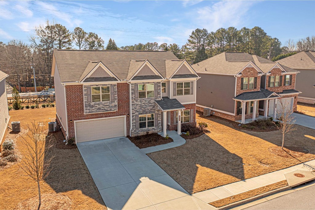 an aerial view of a house with a driveway and other houses