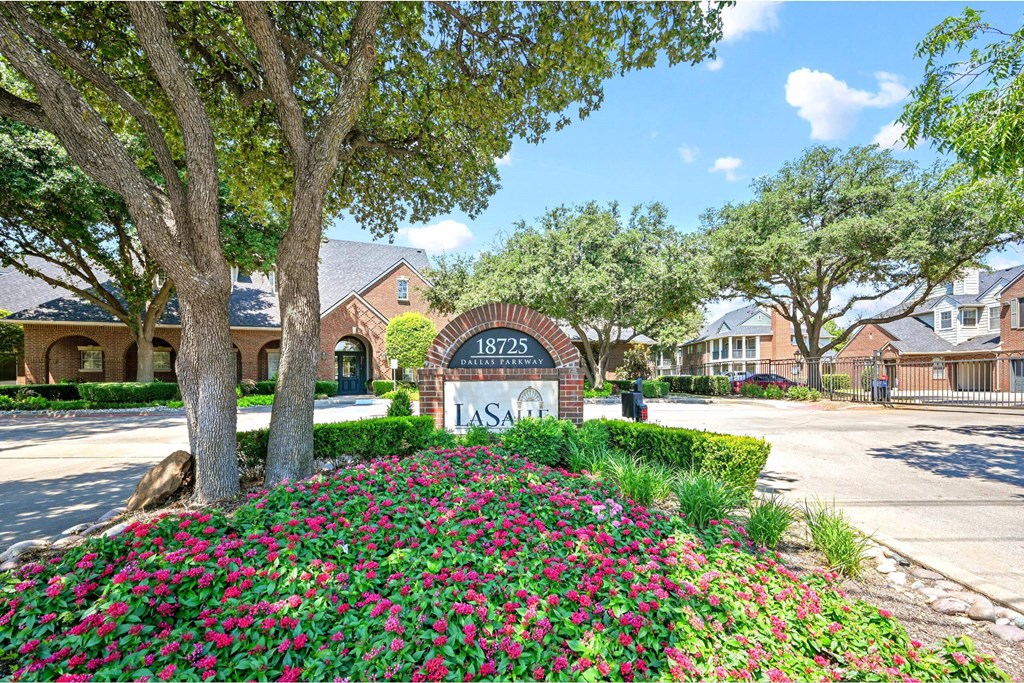 a building with a sign and flowers in front of it