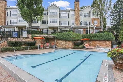 a swimming pool with an apartment building in the background